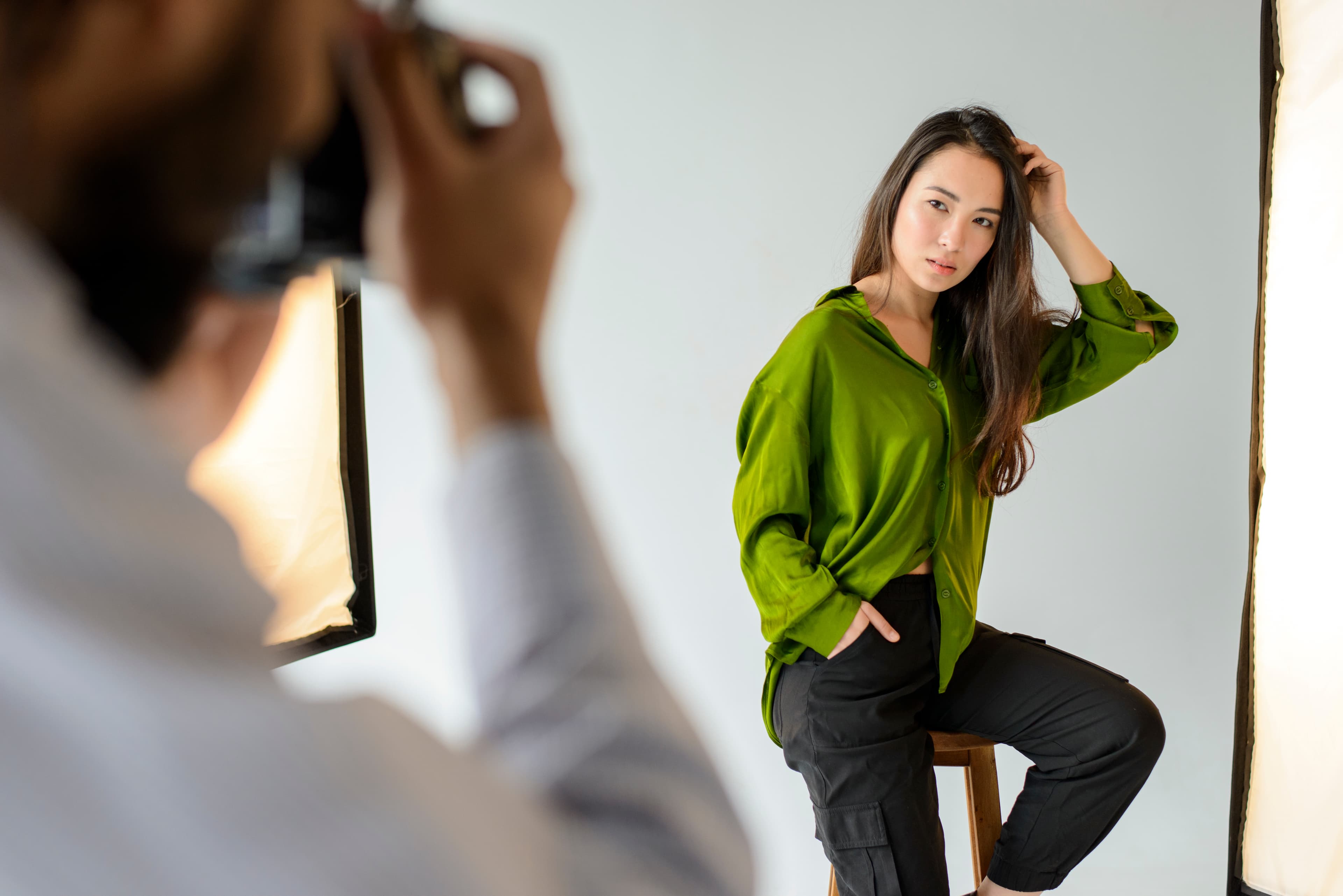 Photographer taking a portrait of a young woman in the studio